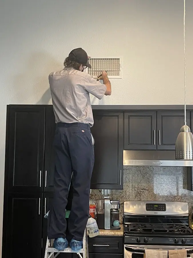Technician inspecting an air vent during HVAC service in Chester